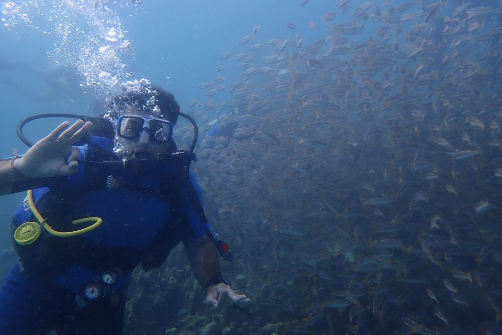 Beginner diver giving a thumbs-up underwater beside a Bond Safari instructor